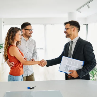 Property Lawyer shaking hands with young new homeowners in Sydney